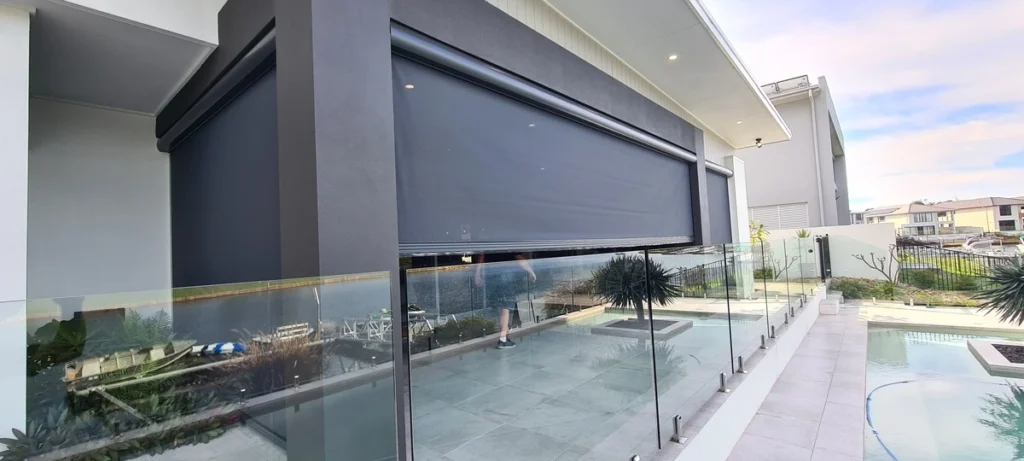 Outdoor blinds half way closed on entertainment area next to the pool