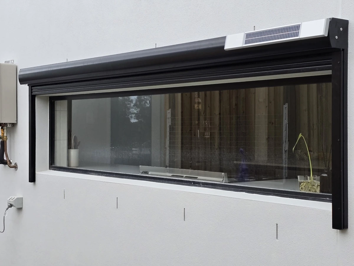 Outdoor roller blinds over kitchen window