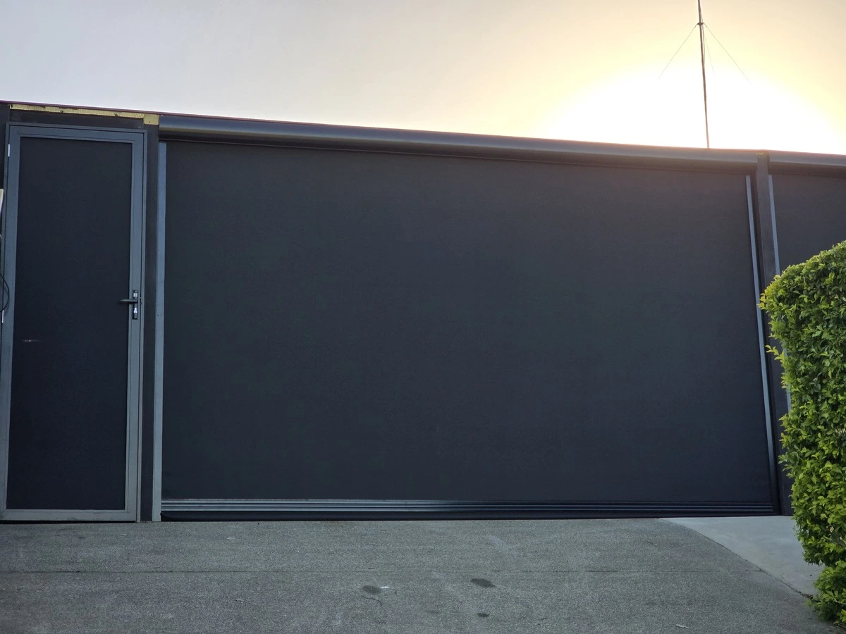 Close up of our door blinds with a sunset in the background