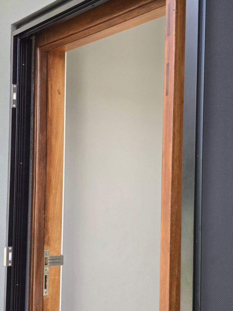 Custom frame built to fit a security screen door onto a pivot door