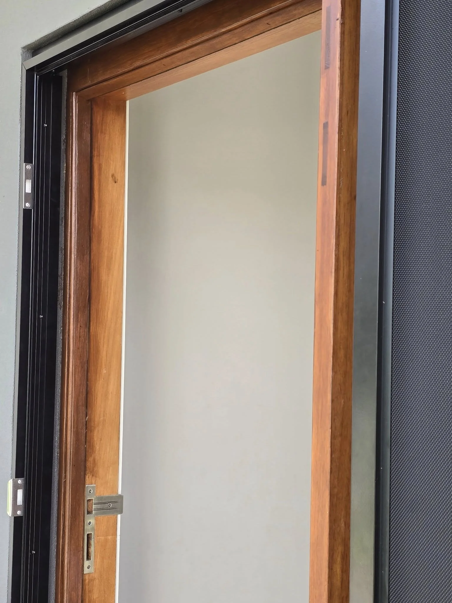 Custom frame built to fit a security screen door onto a pivot door